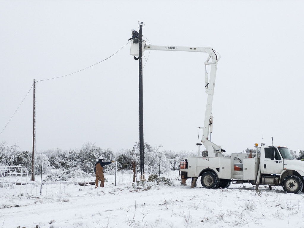 Repairmen attempting to fix a disconnected power pole during the 2021 Texas Power Crisis.